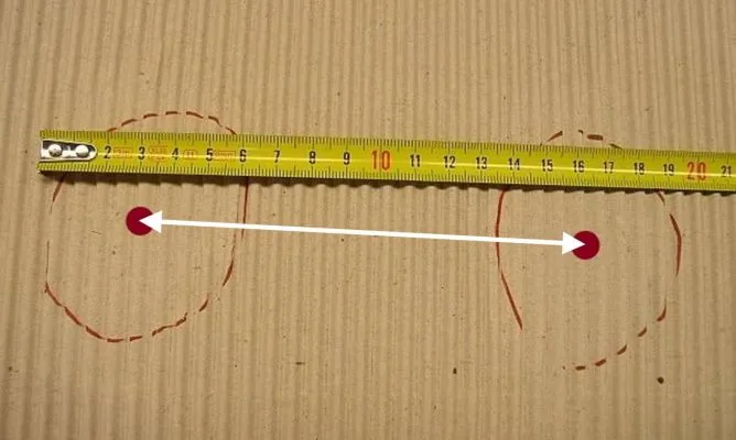 Schematic of two sit bone imprints on cardboard with the distance between the centres indicated